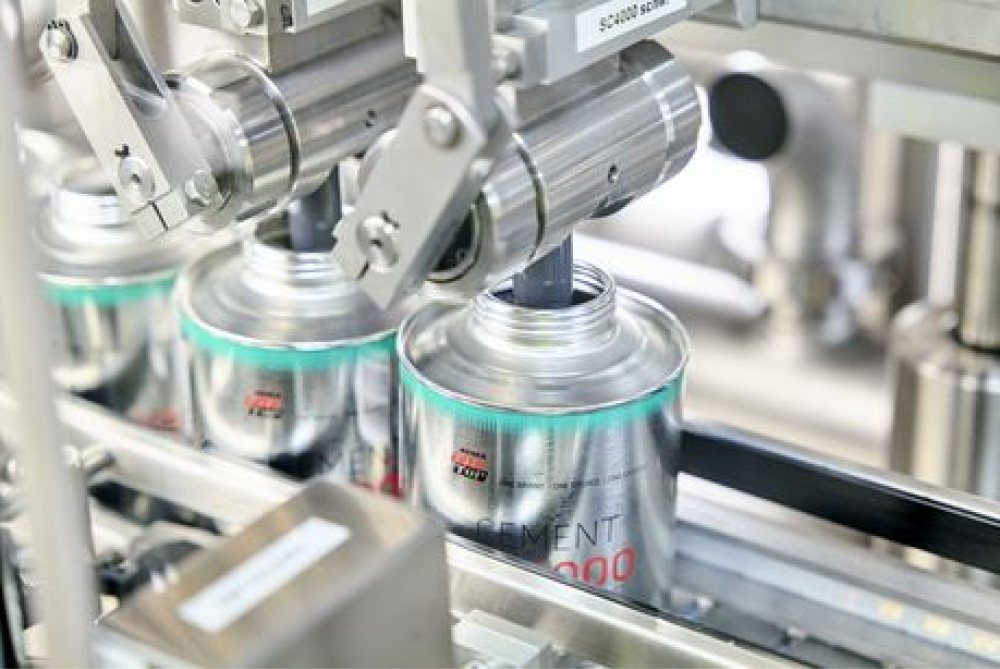 Canisters are filled by machine on a conveyor belt